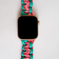 an apple watch with a pink and green braided band