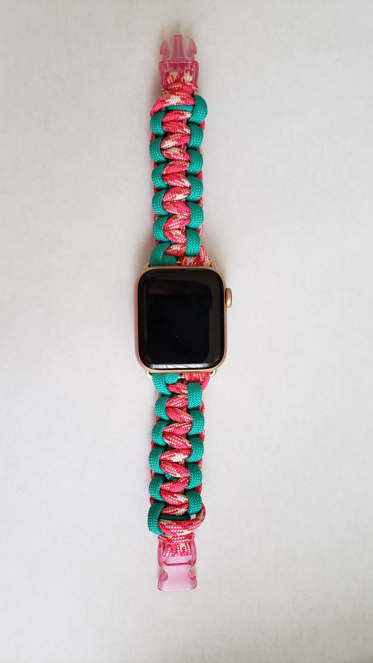 an apple watch with a pink and turquoise band