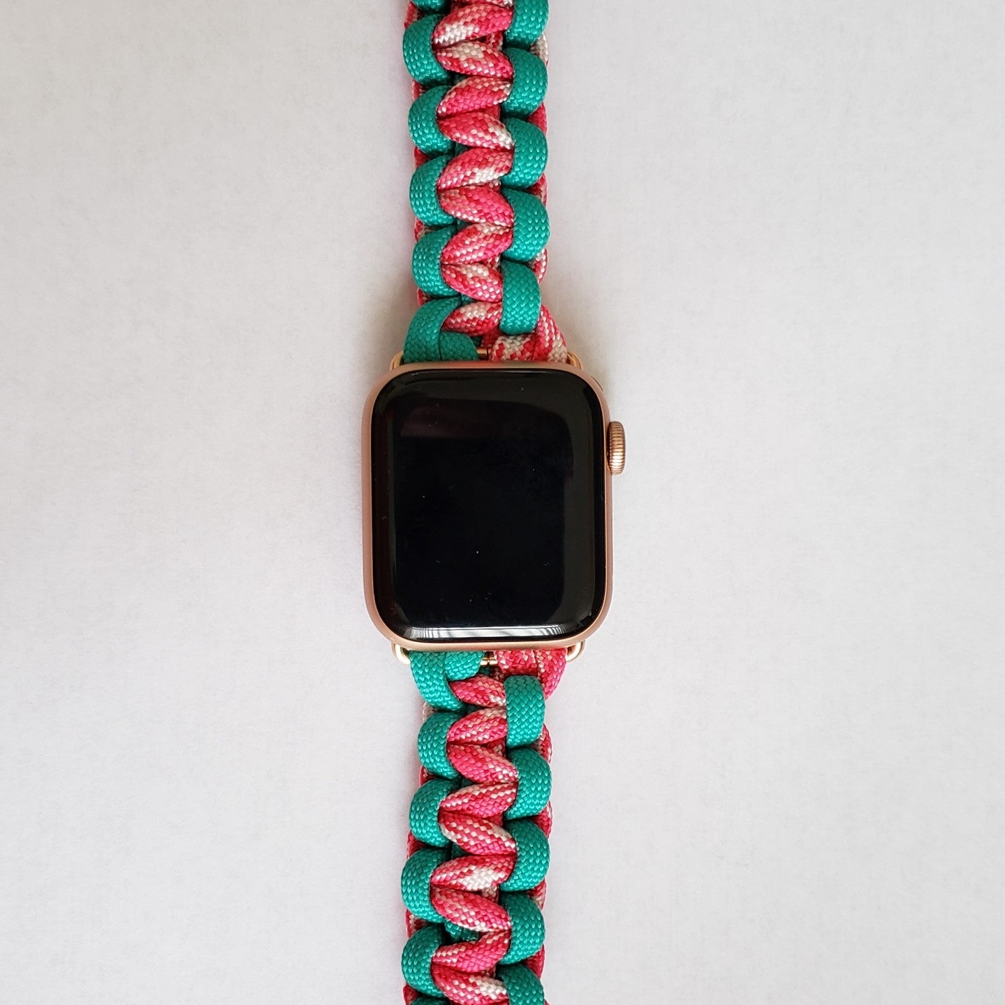 an apple watch with a pink and green band