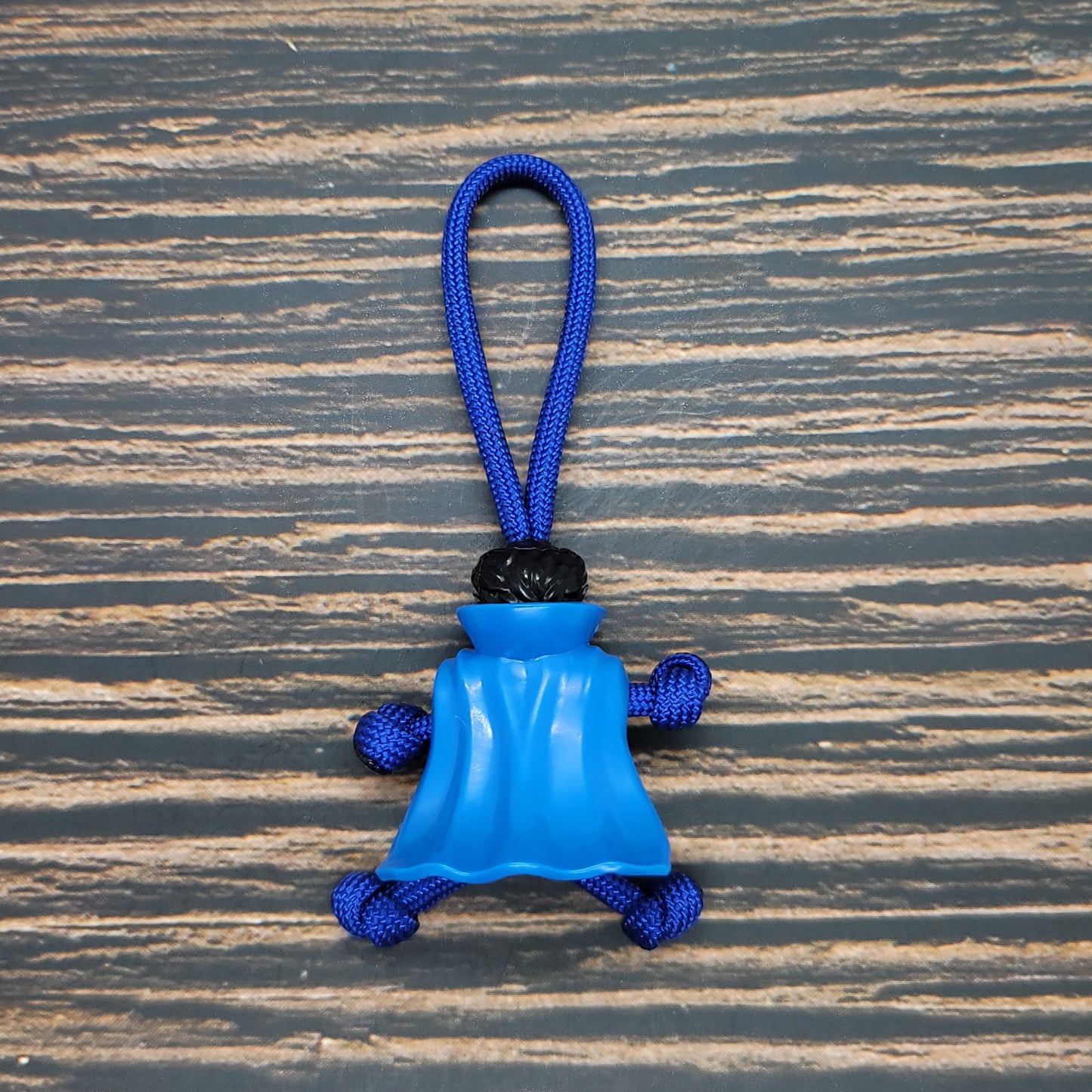 a blue toy hanging on a wooden surface