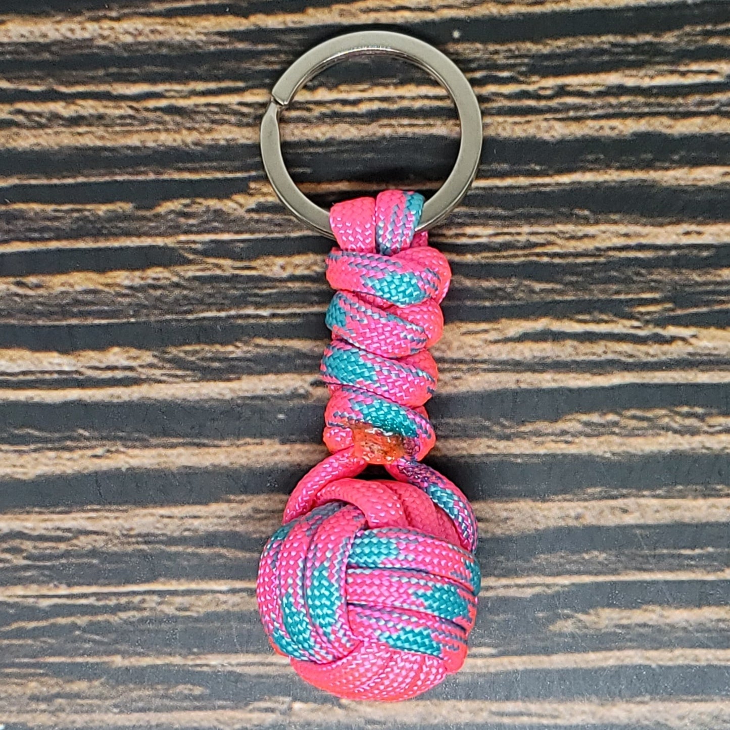 a pink and blue rope wrapped around a metal keychain