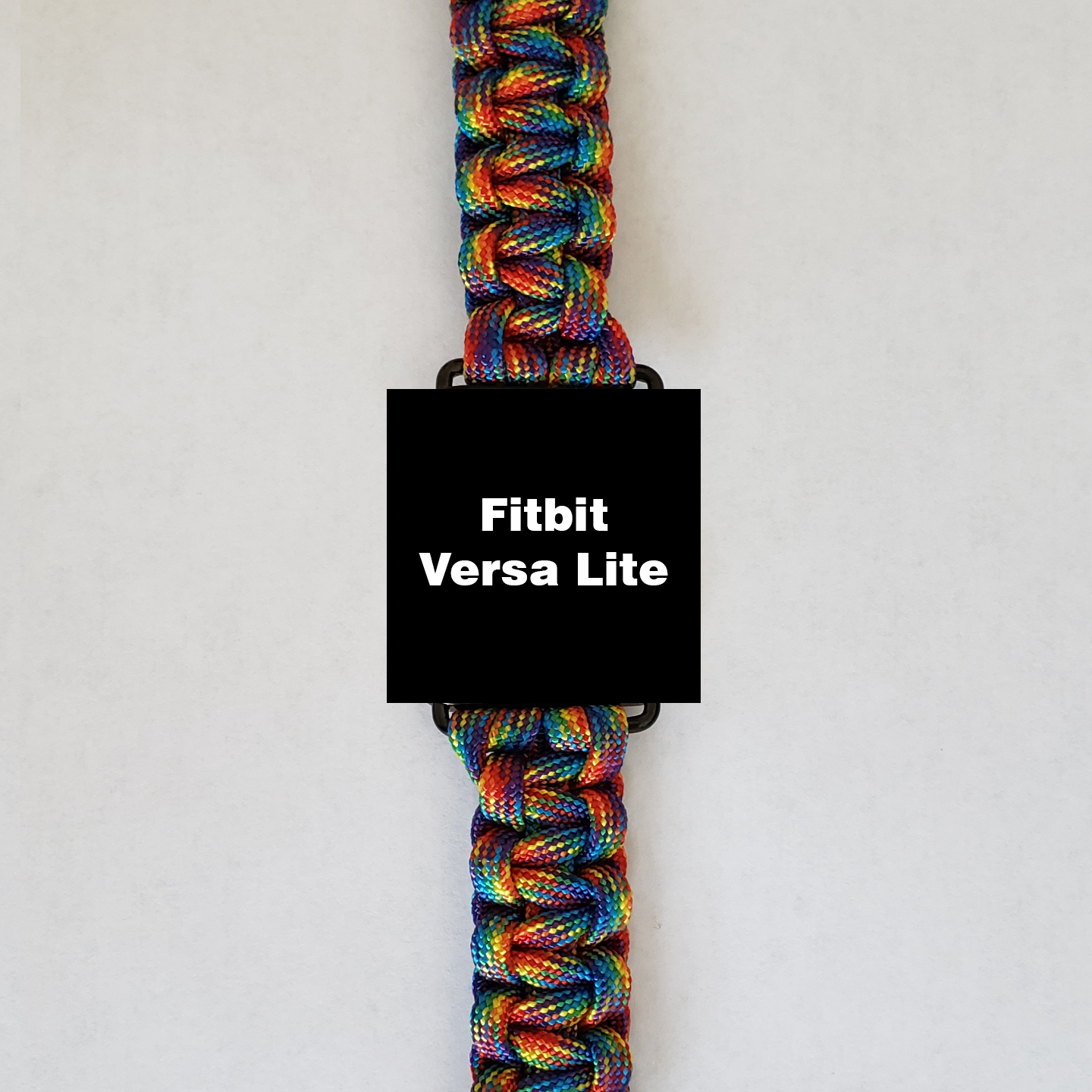 An Insanely Paracord Fitbit Versa Lite Paracord Watch Bands - Durable, Stylish, and Customizable smartwatch with a screen displaying the text "Fitbit Versa Lite" is shown. It features a high-quality paracord watch band in a woven pattern, predominantly showcasing red, blue, green, and yellow hues. The background is plain white.