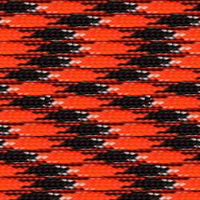 A close-up of a woven fabric featuring a repetitive geometric pattern with interlocking shapes in black and orange, accented by small white dots. The texture appears tightly knit and reminiscent of high strength cord like "Orange You Happy" 550 Paracord - High-Strength & Versatile Made in USA by Insanely Paracord, giving it a detailed and intricate appearance perfect for emergency and survival situations.
