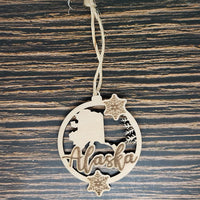 a wooden ornament with the word alaska hanging from a string