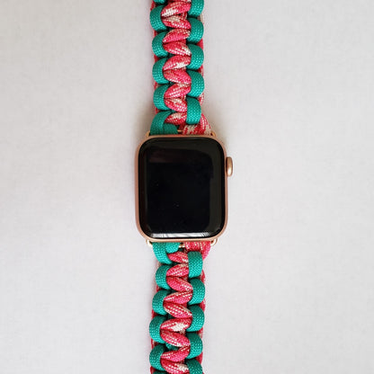 an apple watch with a pink and green band