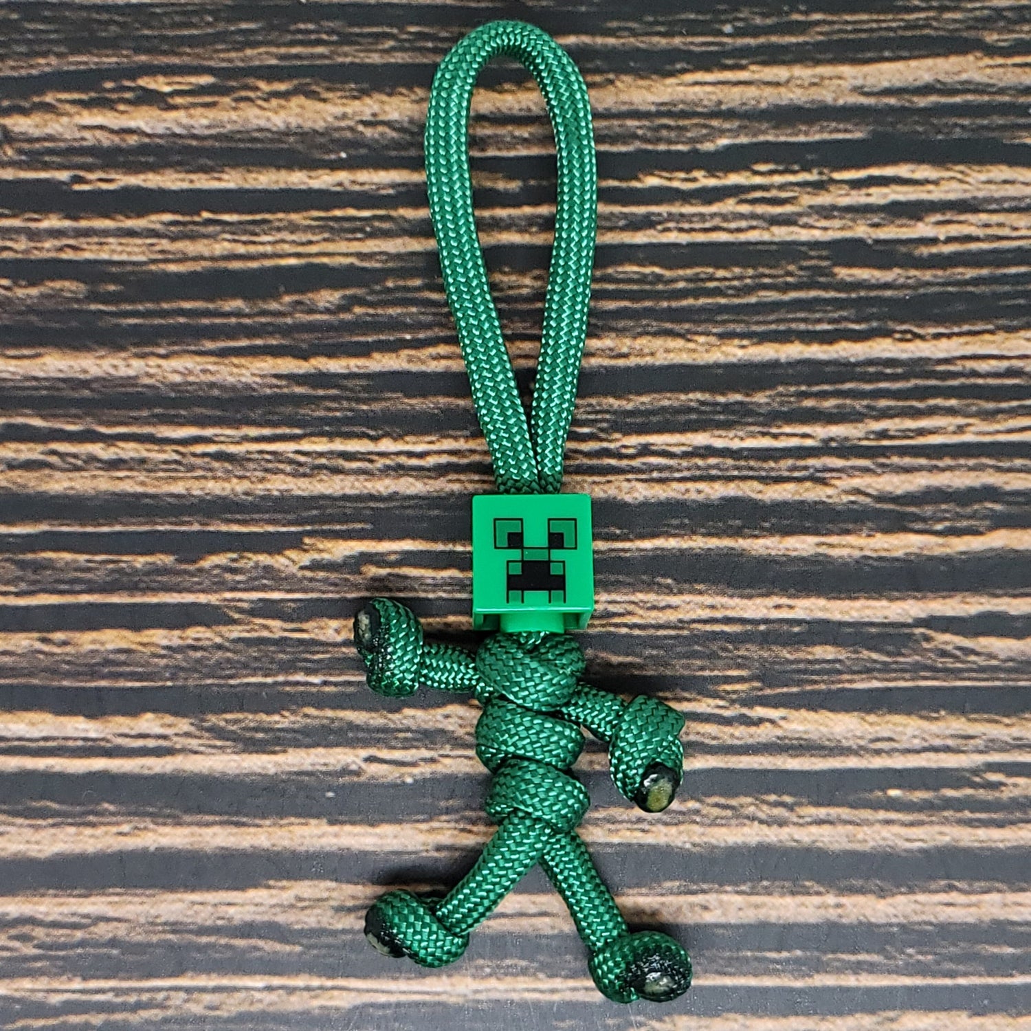 a green keychain with a small robot on it