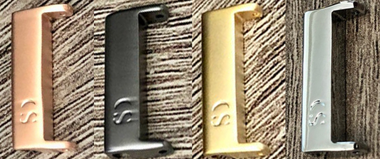 Four Gear Sport Paracord Watch Bands by Insanely Paracord, each showcased in different metallic finishes: copper, black, gold, and silver, are lined up horizontally on a textured surface. Each high-quality band features an engraved logo appealing to outdoor enthusiasts who appreciate craftsmanship akin to paracord watch bands.