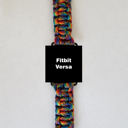 An Insanely Paracord Fitbit Versa Paracord Watch Band - Durable, Stylish, & Customizable with a vibrant, high-quality paracord band made of multicolored strands. The rainbow spectrum of the paracord watch bands stands out, while the watch face displays "Fitbit Versa" on a black background. Perfect for outdoor activities, it is set against a plain white backdrop.