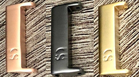 Three metallic E-shaped tools are displayed on a textured surface. Each tool is a different color: one is copper, one is black, and one is gold. Perfect for outdoor enthusiasts, these "Paracord Watch Band - Durable 2-Color Design for Apple, Fitbit, Samsung" from Insanely Paracord feature the "CS" logo on their side and can double as smartwatch accessories or paracord watch bands.