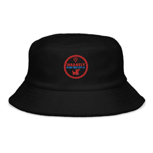 A black Terry Cloth Bucket Hat | 100% Cotton | Classic Brim | One Size Fits Most featuring a red and blue embroidered circular logo on the front. The logo has the words "Insanely Paracord" surrounding a small image of parachute lines, giving it an adventure-themed design—perfect as a summer accessory for your beachwear collection.